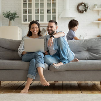 Personal ValuePlus Checking Features and Benefits.  Family sitting on couch looking at computer.